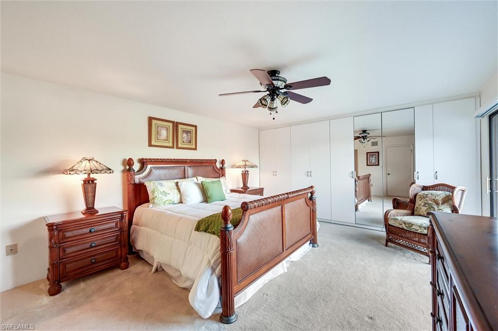 185 Lake Point Lane, Unit 8B Naples, FL 34112 - Photo 19 of 34 a bed room with a bed and a chair