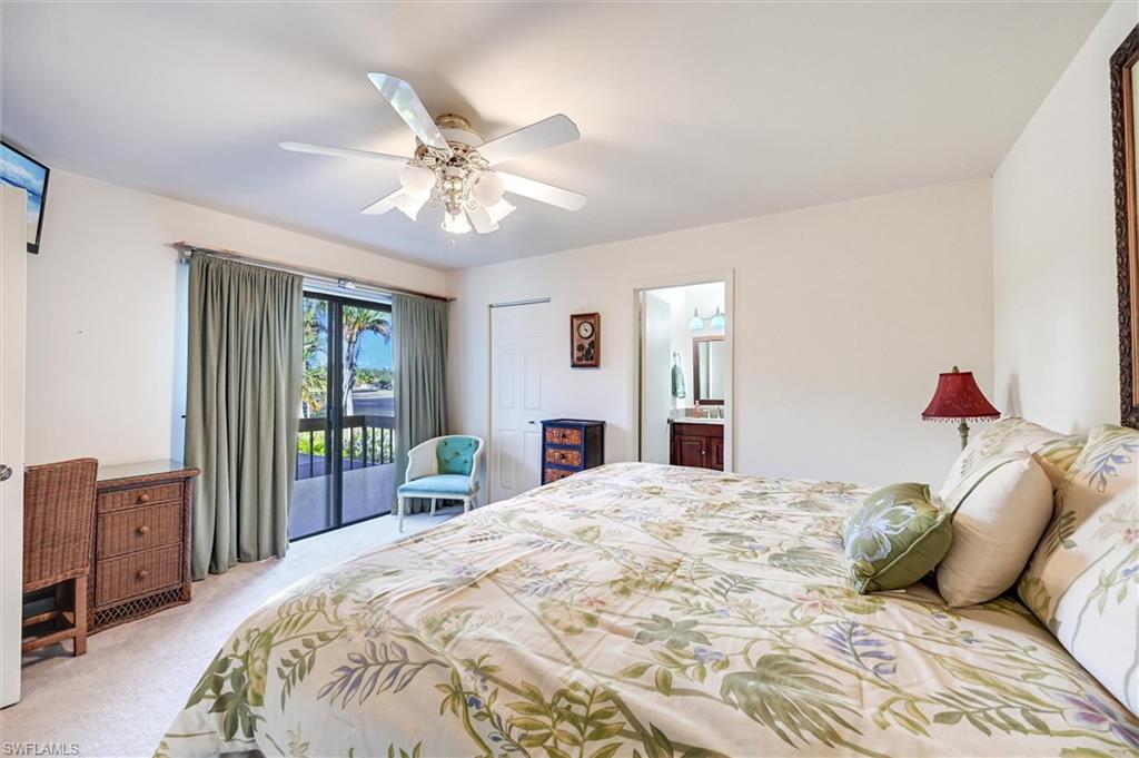 185 Lake Point Lane, Unit 8B Naples, FL 34112 - Photo 24 of 34 a bedroom with a bed and a chandelier