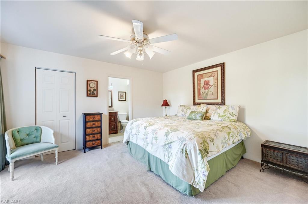 185 Lake Point Lane, Unit 8B Naples, FL 34112 - Photo 25 of 34 a bedroom with a bed and a chandelier