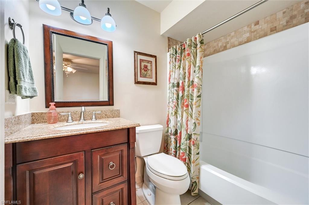185 Lake Point Lane, Unit 8B Naples, FL 34112 - Photo 26 of 34 a bathroom with a granite countertop toilet sink and mirror