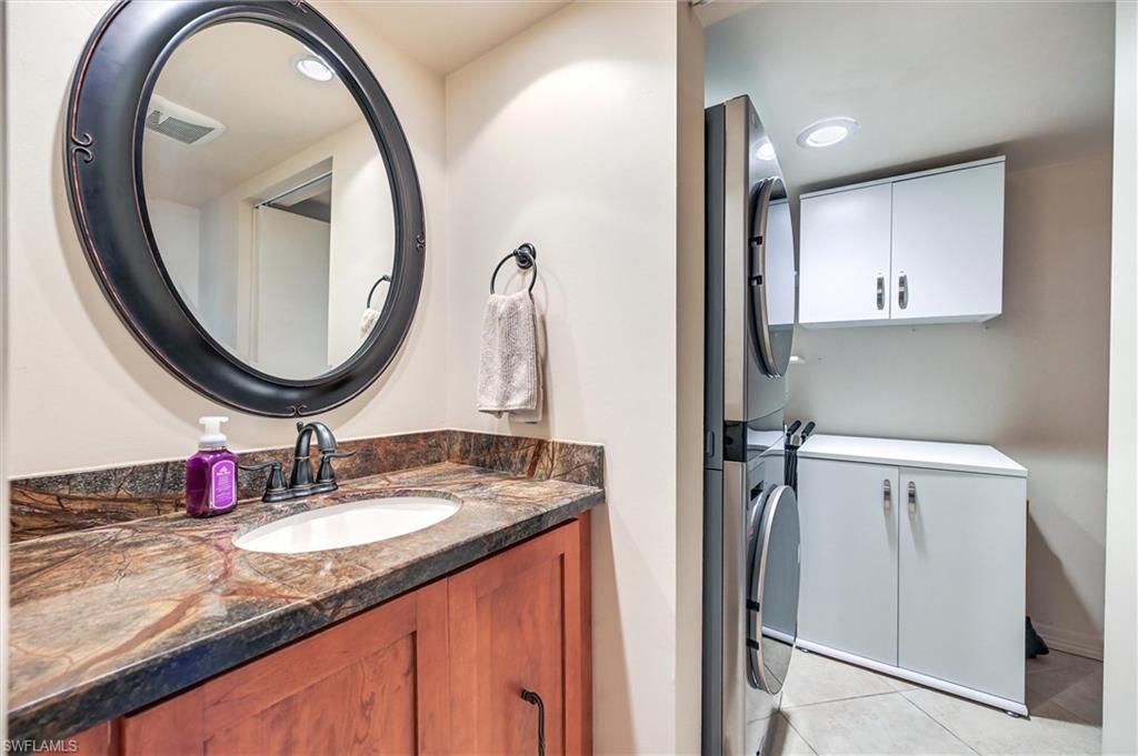 185 Lake Point Lane, Unit 8B Naples, FL 34112 - Photo 28 of 34 a bathroom with a granite countertop double vanity sink and a mirror