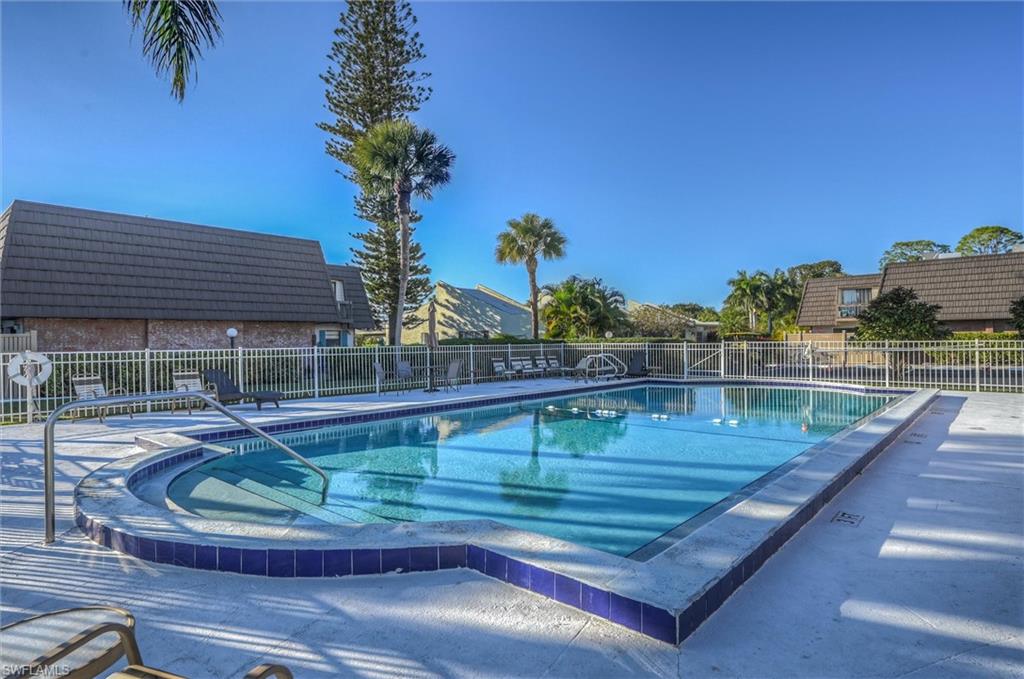 185 Lake Point Lane, Unit 8B Naples, FL 34112 - Photo 31 of 34 a view of a swimming pool with a table and chair