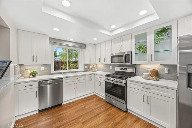 a kitchen with a stove a sink and white cabinets