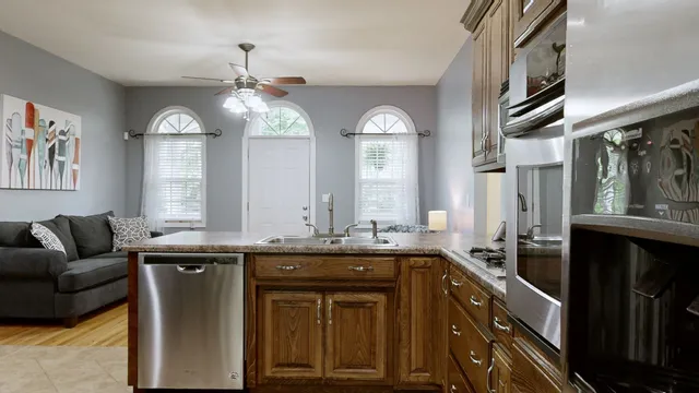 a kitchen with stainless steel appliances granite countertop a sink a stove and a microwave