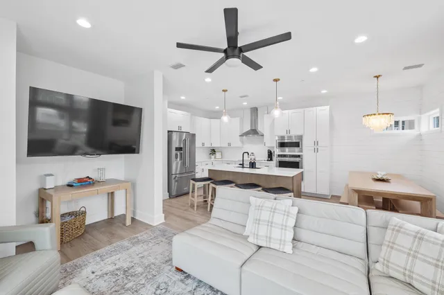 a kitchen with a refrigerator a stove a sink and a wooden floor