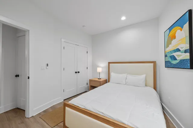 a bedroom with a bed and a painting on the wall