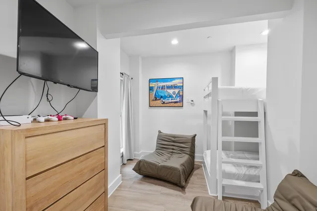 a kitchen with stainless steel appliances kitchen island granite countertop a stove a sink a dining table and chairs with wooden floor