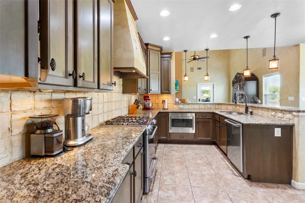 a kitchen with stainless steel appliances granite countertop a sink stove and refrigerator