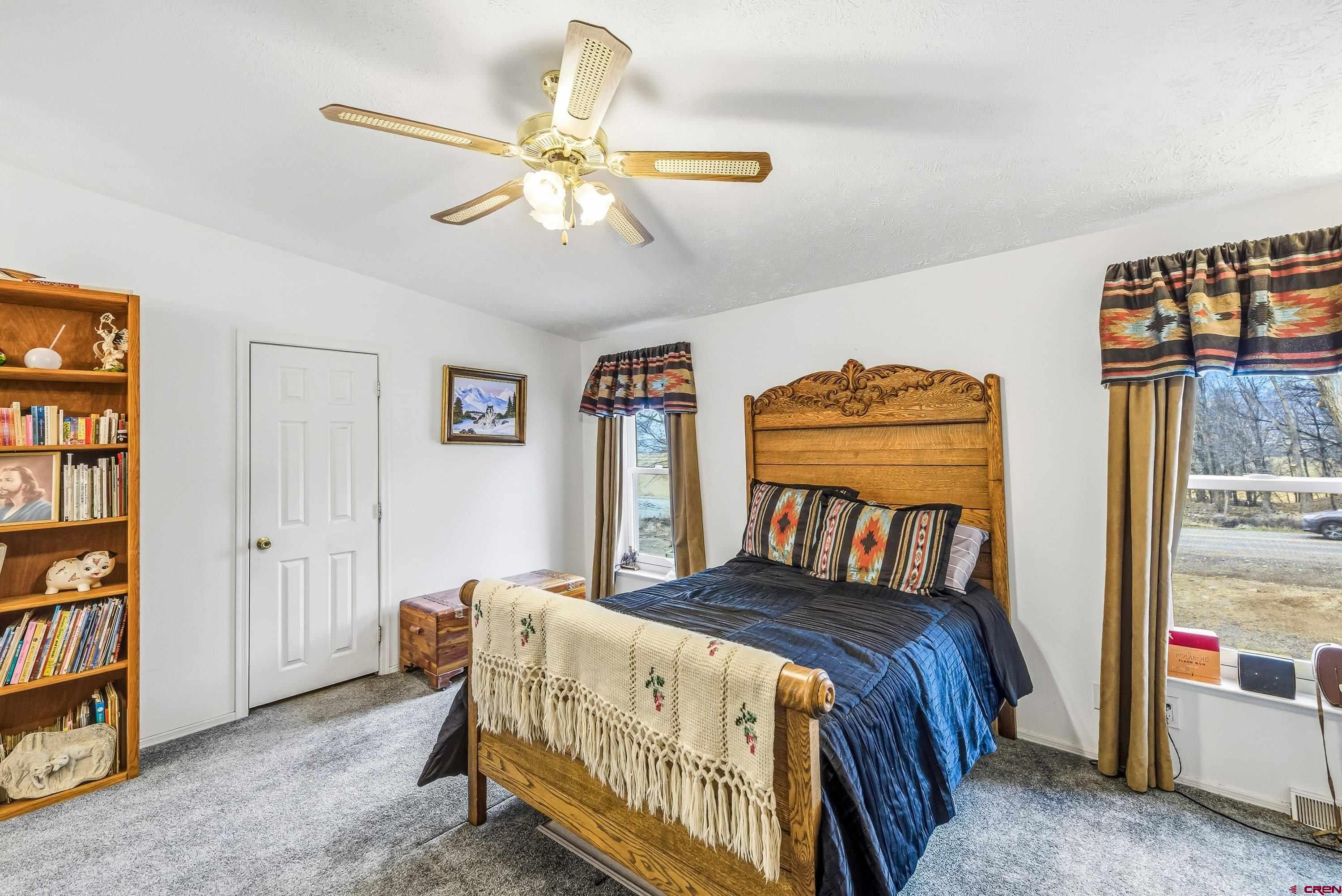 14414 G Road Delta, CO 81416 - Photo 12 of 39 a bedroom with a bed and a chandelier