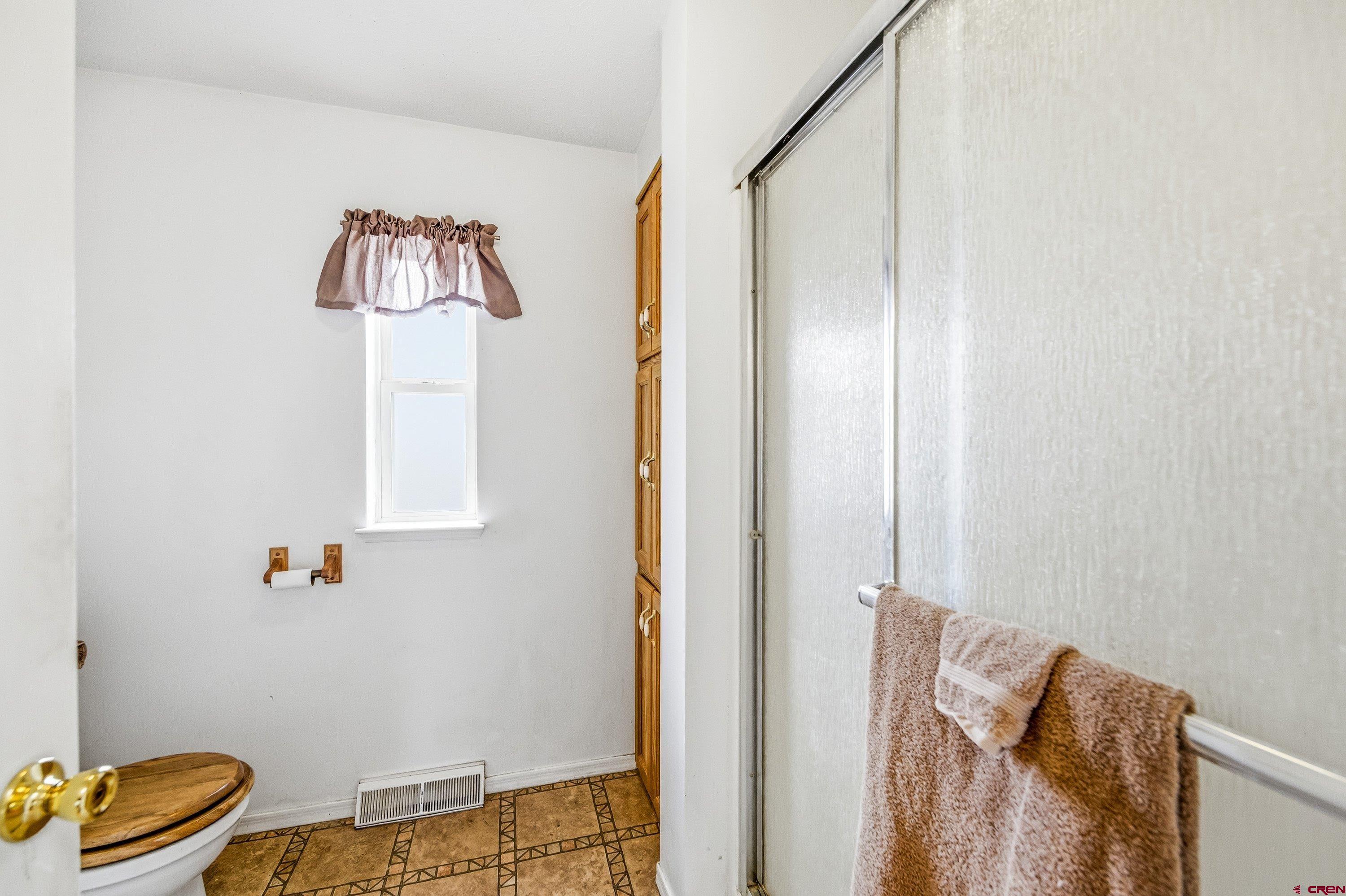 14414 G Road Delta, CO 81416 - Photo 15 of 39 a bathroom with a shower and a painting on the wall