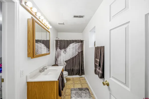 a bathroom with a sink and mirror with bathtub