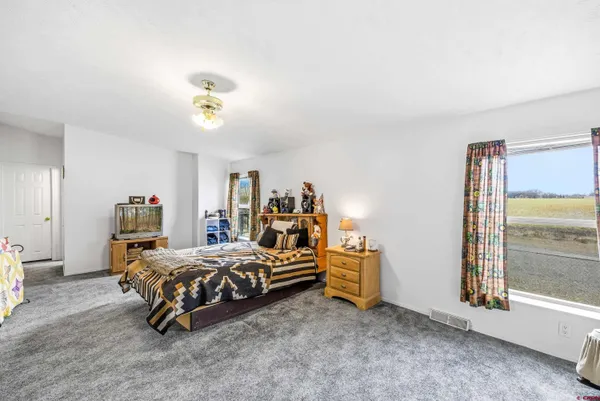 a bedroom with a bed and large windows