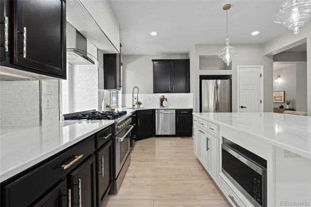 a large kitchen with stainless steel appliances a sink and a refrigerator