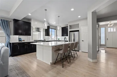 a kitchen with a table chairs refrigerator and microwave
