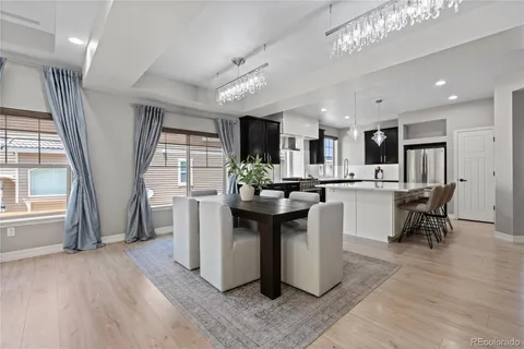 a kitchen with stainless steel appliances kitchen island granite countertop a table chairs sink and cabinets