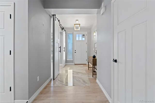 a view of a hallway with wooden floor and a bathroom