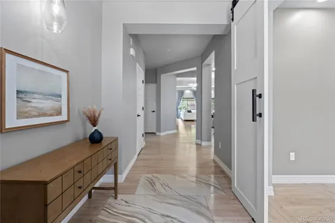 a view of a hallway with wooden floor and a bathroom