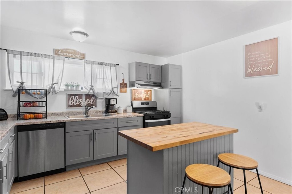 1417 West Marshall Boulevard San Bernardino, CA 92405 - Photo 12 of 39 a kitchen with a sink a stove a counter space and cabinets