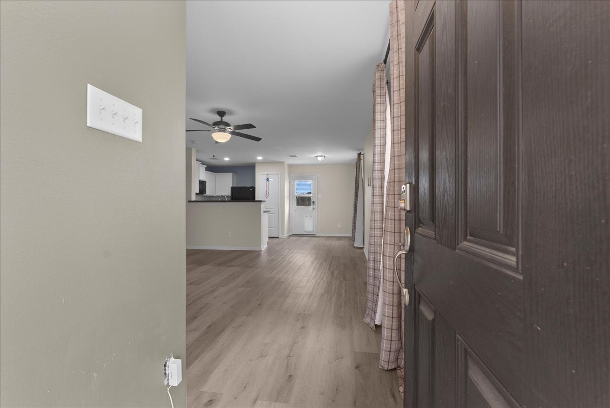 5727 Treasure Cove Road Cove, TX 77523 - Photo 3 of 20 a view of a hallway with wooden floor and a kitchen