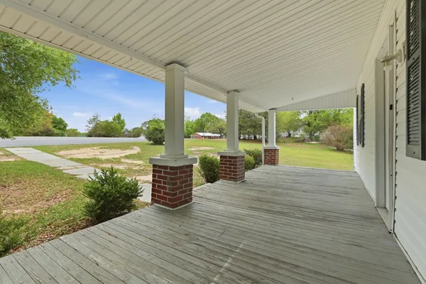 a view of a room with wooden floor and floor to ceiling windows with garden