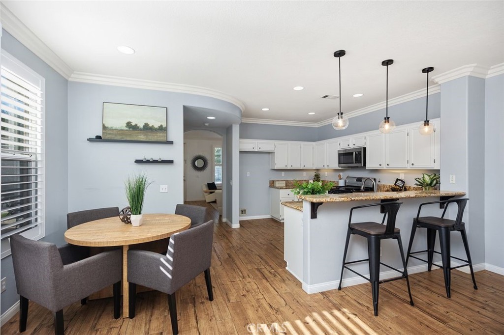 8 Tradition Lane Rancho Santa Margarita, CA 92688 - Photo 7 of 43 a kitchen with stainless steel appliances kitchen island a table and chairs in it