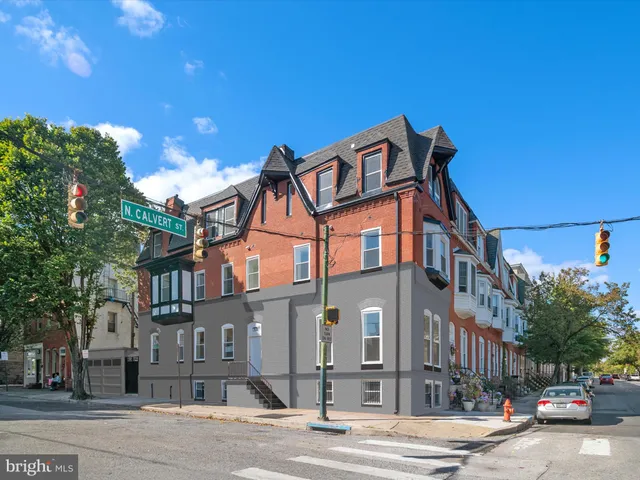 a front view of a house with a tree