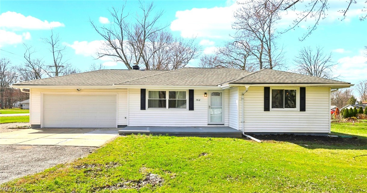 7412 Hopkins Road Mentor, OH 44060 - Photo 2 of 36 Ranch-style house featuring concrete driveway, an attached garage, a shingled roof, and a front lawn