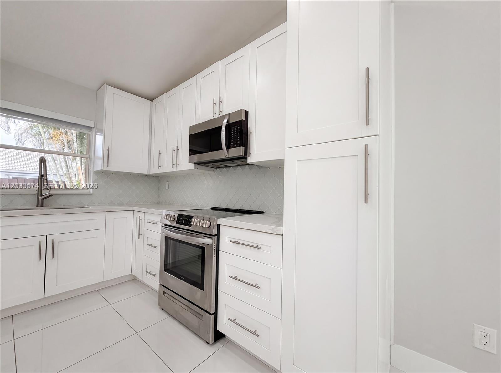 16571 Southwest 145th Avenue Miami, FL 33177 - Photo 11 of 25 a kitchen with white cabinets stainless steel appliances and window