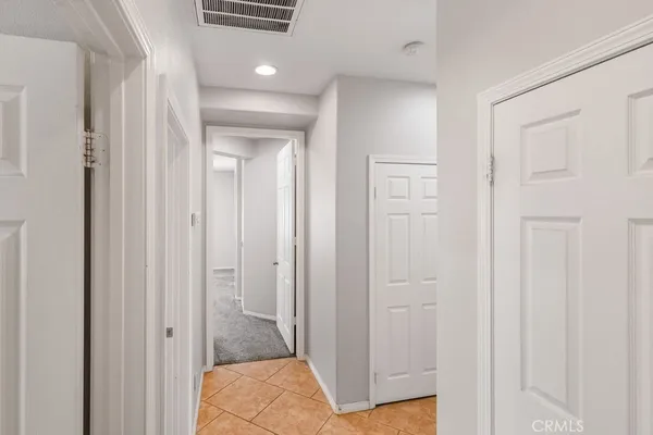 a view of a hallway with wooden floor and closet area