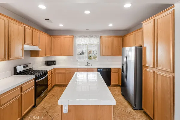 a kitchen with stainless steel appliances granite countertop refrigerator sink and cabinets
