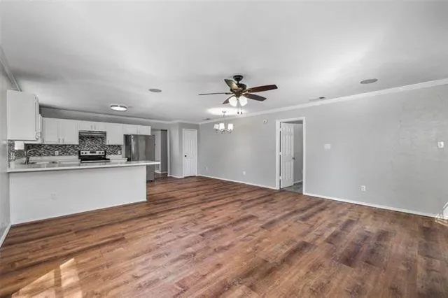 a view of kitchen with kitchen island wooden floor center island and stainless steel appliances