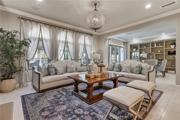 a living room with furniture a chandelier and a table