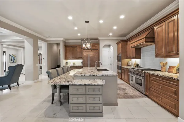 a kitchen with kitchen island granite countertop wooden cabinets and a refrigerator