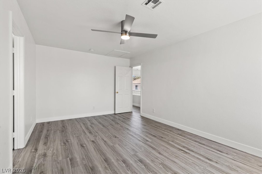 1412 Beaver Spring Street Las Vegas, NV 89128 - Photo 12 of 20 Well-lit room features durable wood flooring and an efficient ceiling fan for comfort.