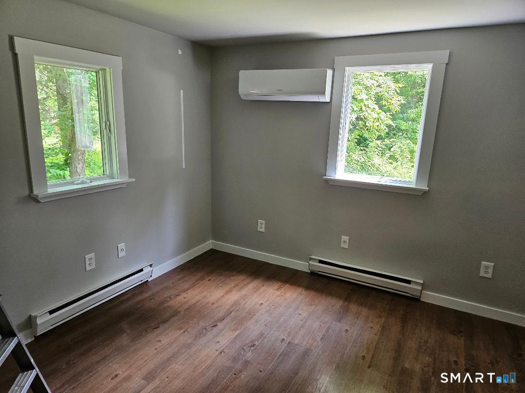 300 Railtree Hill Road Woodbury, CT 06798 - Photo 5 of 7 an empty room with wooden floor and windows