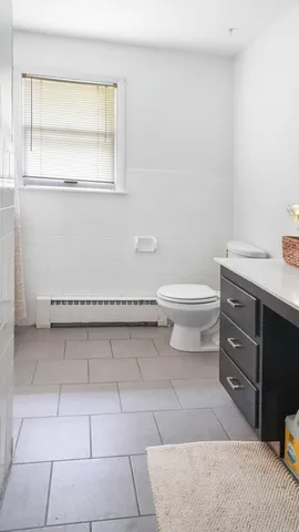 a bathroom with a toilet a sink and window