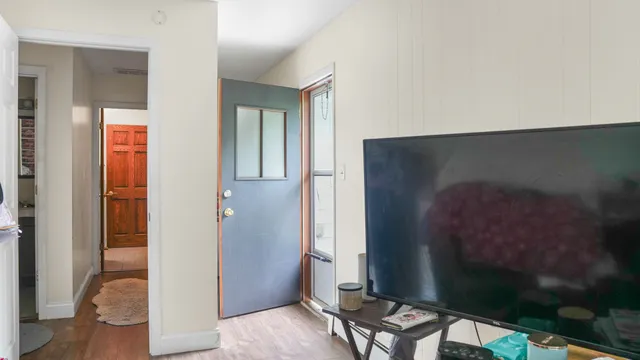 a view of a hallway with wooden floor and a bedroom