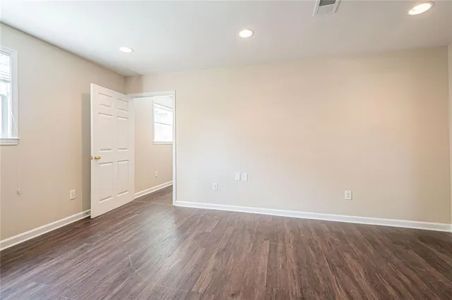 a view of an empty room with wooden floor