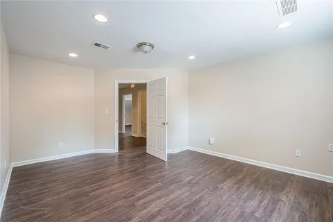 an empty room with wooden floor and natural light