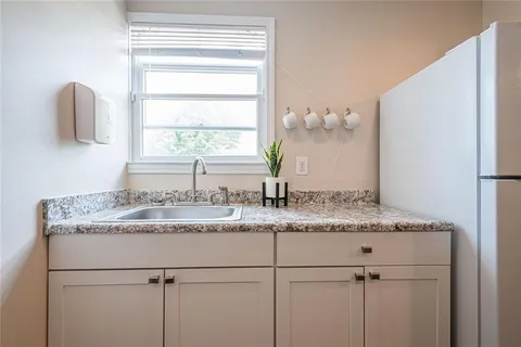 a bathroom with a granite countertop sink and a window