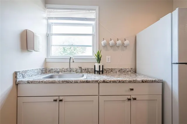 a bathroom with a granite countertop sink and a window
