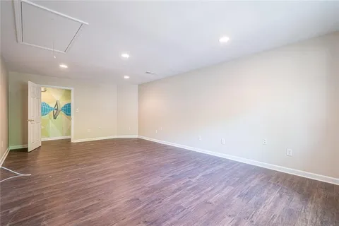 an empty room with wooden floor and natural light