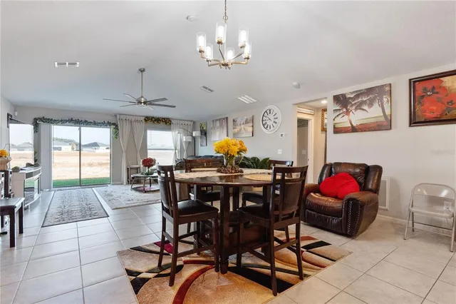 a living room with dining room and kitchen chandelier
