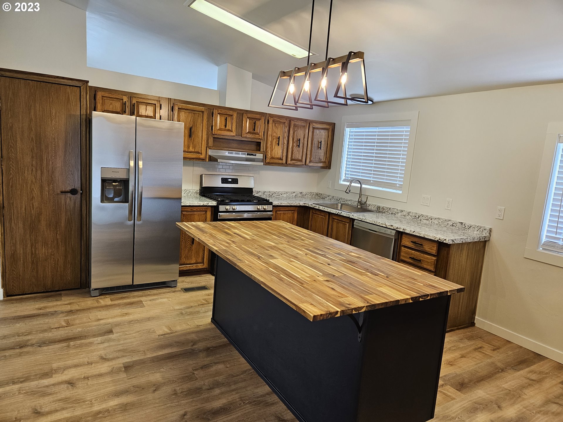 620 Southwest Mildred Avenue Enterprise, OR 97828 - Photo 13 of 26 a kitchen with stainless steel appliances granite countertop a stove and a refrigerator