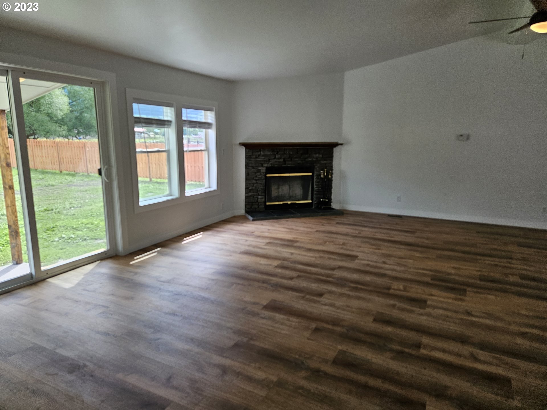 620 Southwest Mildred Avenue Enterprise, OR 97828 - Photo 8 of 26 an empty room with wooden floor fireplace and windows
