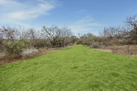 a view of a field with trees in background