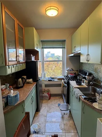 a kitchen with a sink appliances cabinets and a window