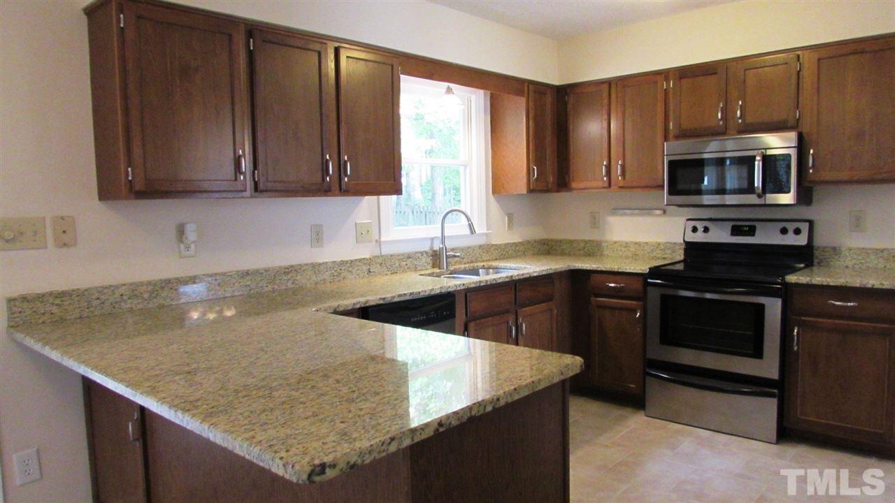 9517 Center Cross Court Raleigh, NC 27617 - Photo 5 of 24 Updated Kitchen with granite counter tops, stainless steel appliances and new tile floors. Refrigerator, washer and dryer convey!