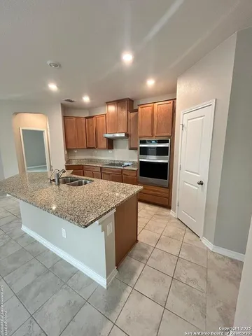 a large kitchen with granite countertop a large counter top and appliances