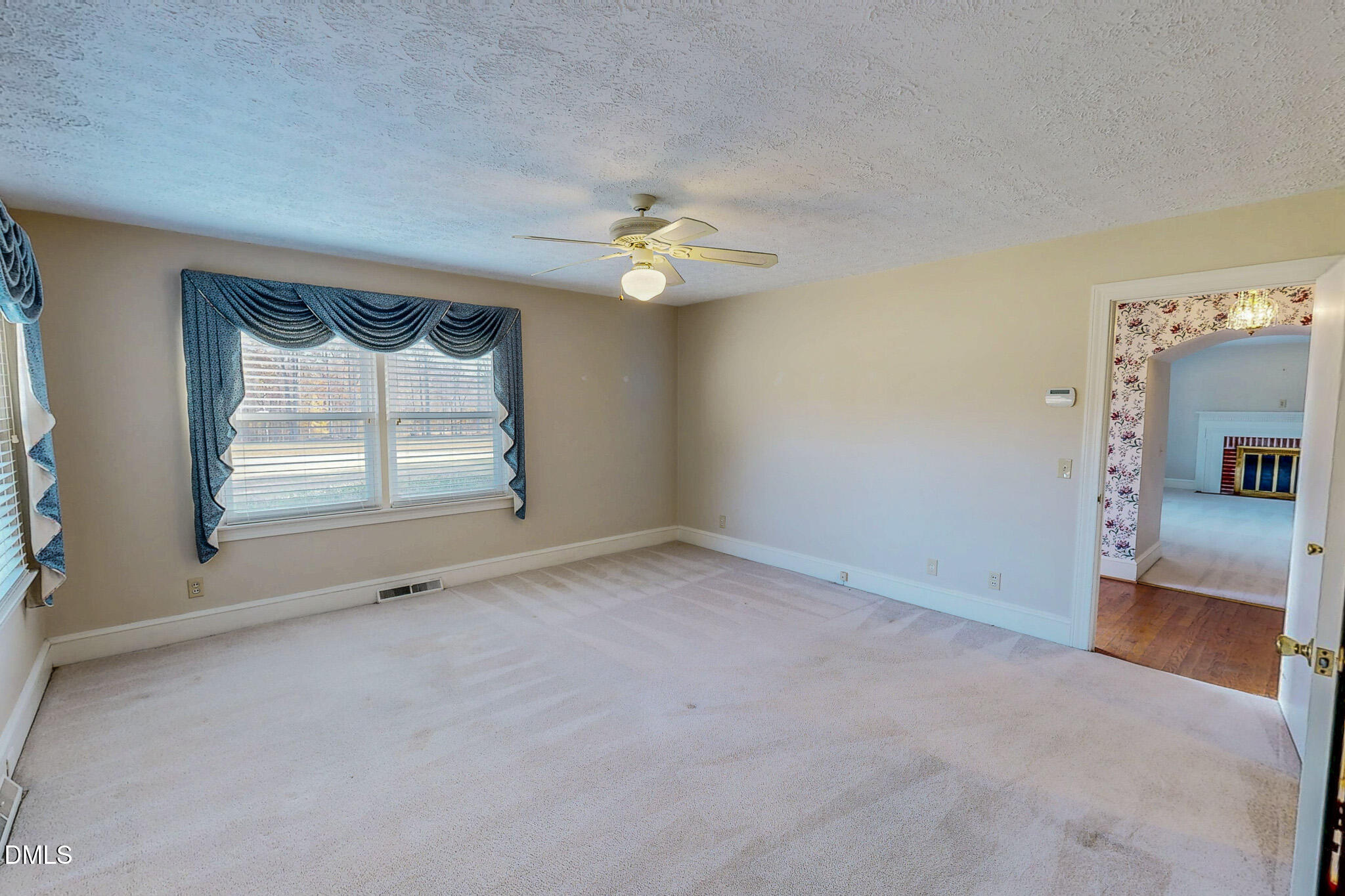 8758 Hurdle Mills Road Hurdle Mills, NC 27541 - Photo 37 of 53 an empty room with chandelier fan and windows